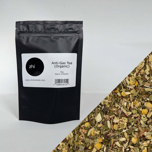 Zhi Herbals Organic Anti-Gas Tea, 50g black package with label, next to a close-up of the yellow and brown tea blend.