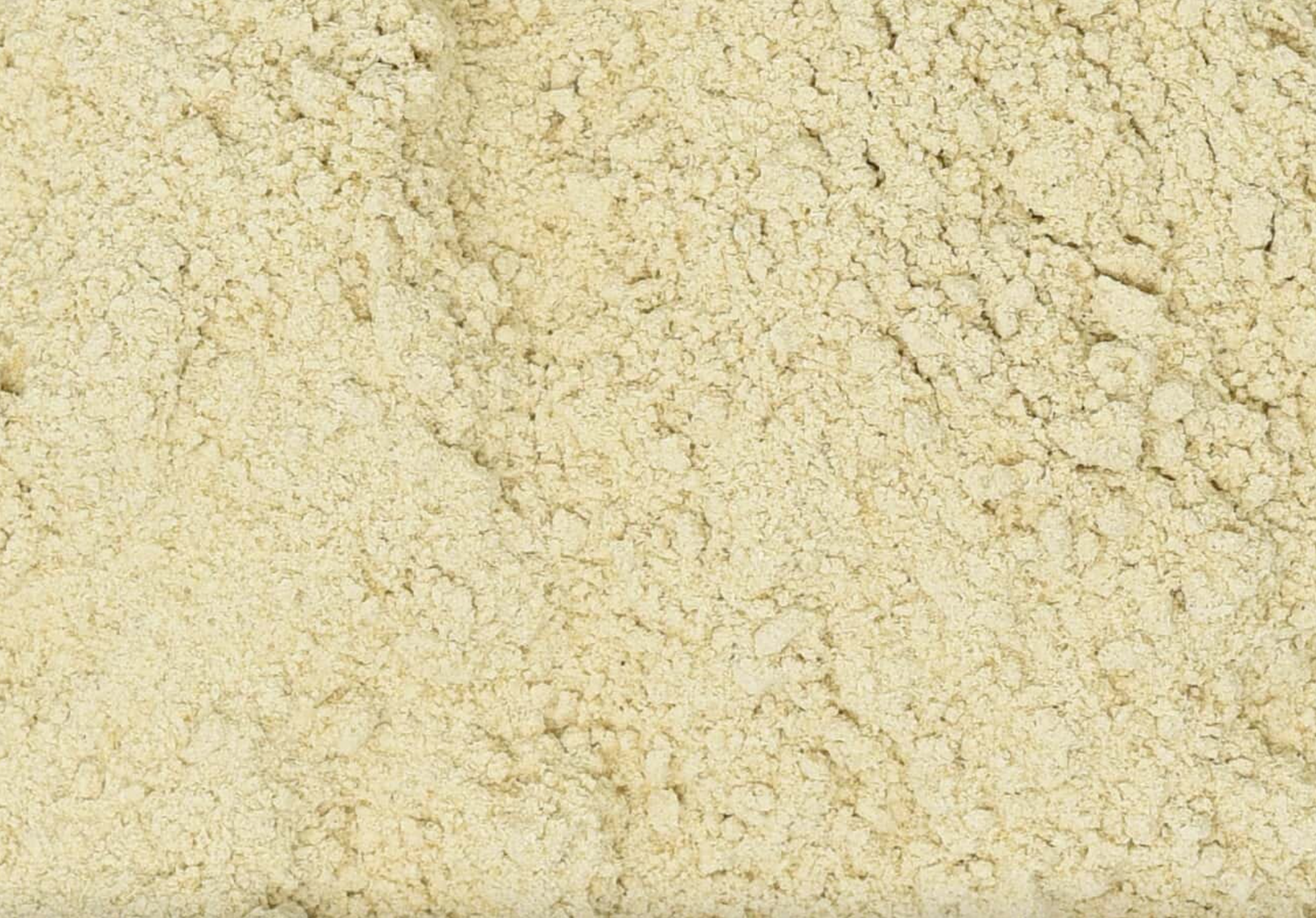 Close-up texture of dried astragalus root powder, showing fine beige powder used for teas and herbal remedies.