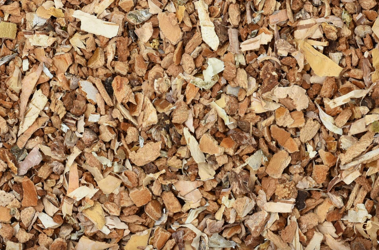 Close-up texture of dried birch bark, showing small light brown pieces used for teas and herbal remedies.