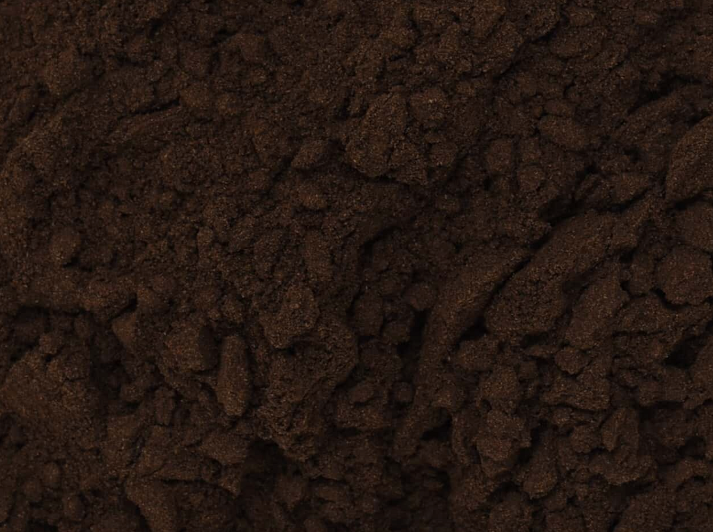 Close-up texture of dried black walnut hull powder, showing dark brown fine powder used for teas and herbal remedies.