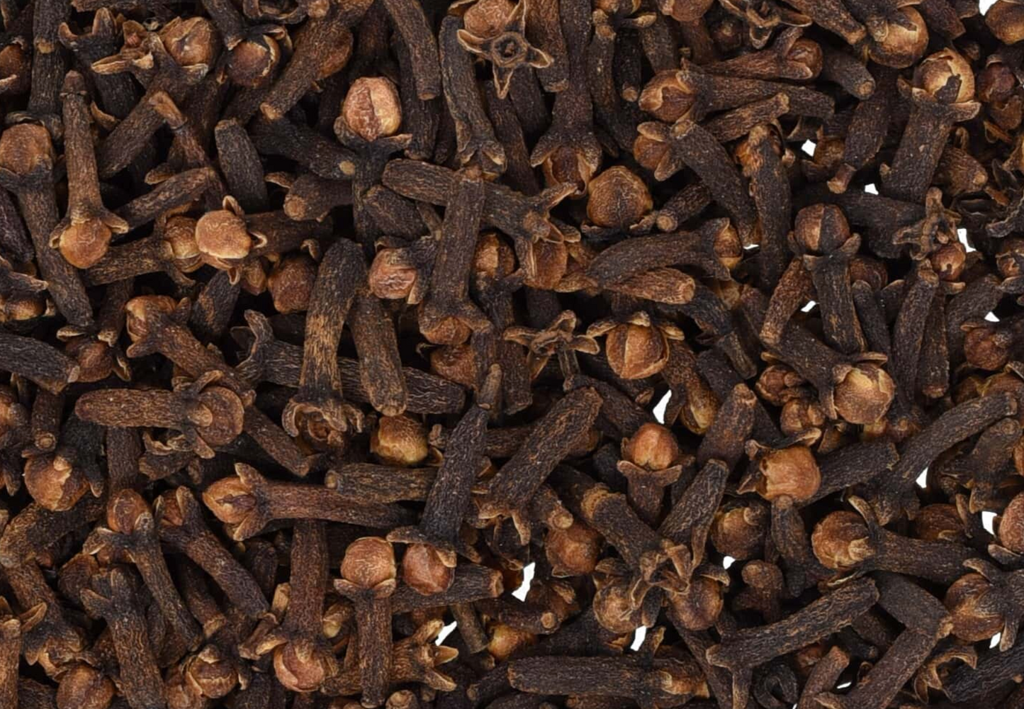 Close-up texture of dried clove buds, showing dark brown cloves used for teas and herbal remedies.