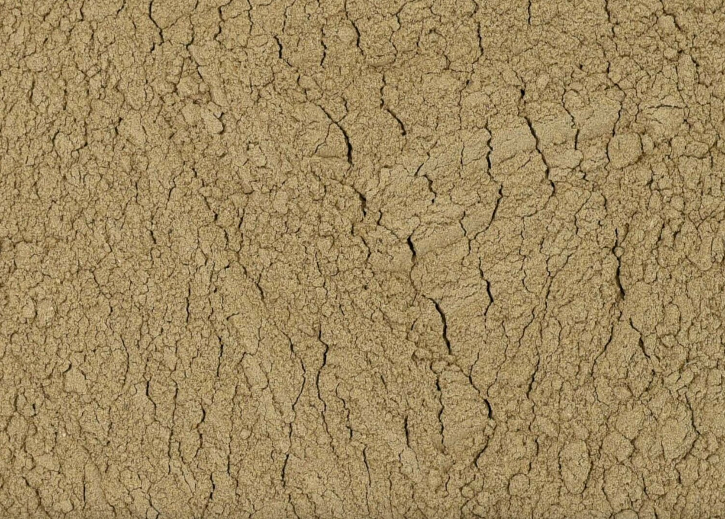 Close-up texture of dried dandelion root powder, showing fine brown powder used for teas and herbal remedies.