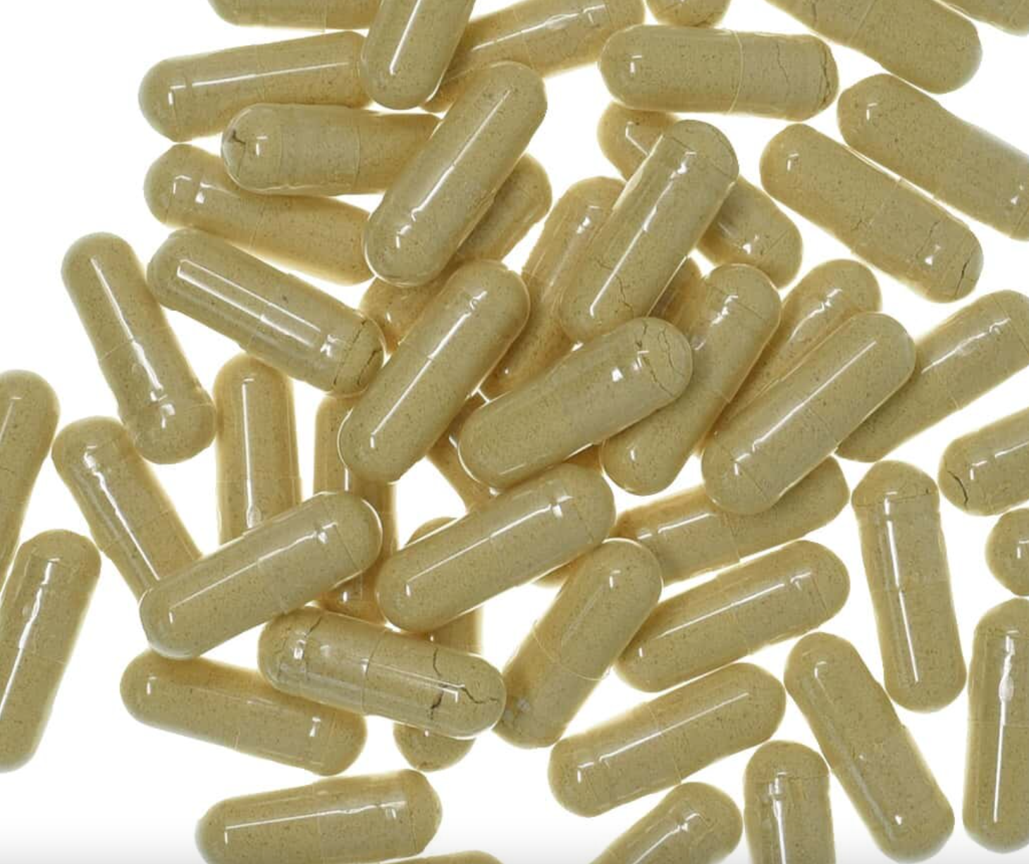 Ginger root capsules with clear glossy shells, filled with beige powder, used for natural health and wellness.