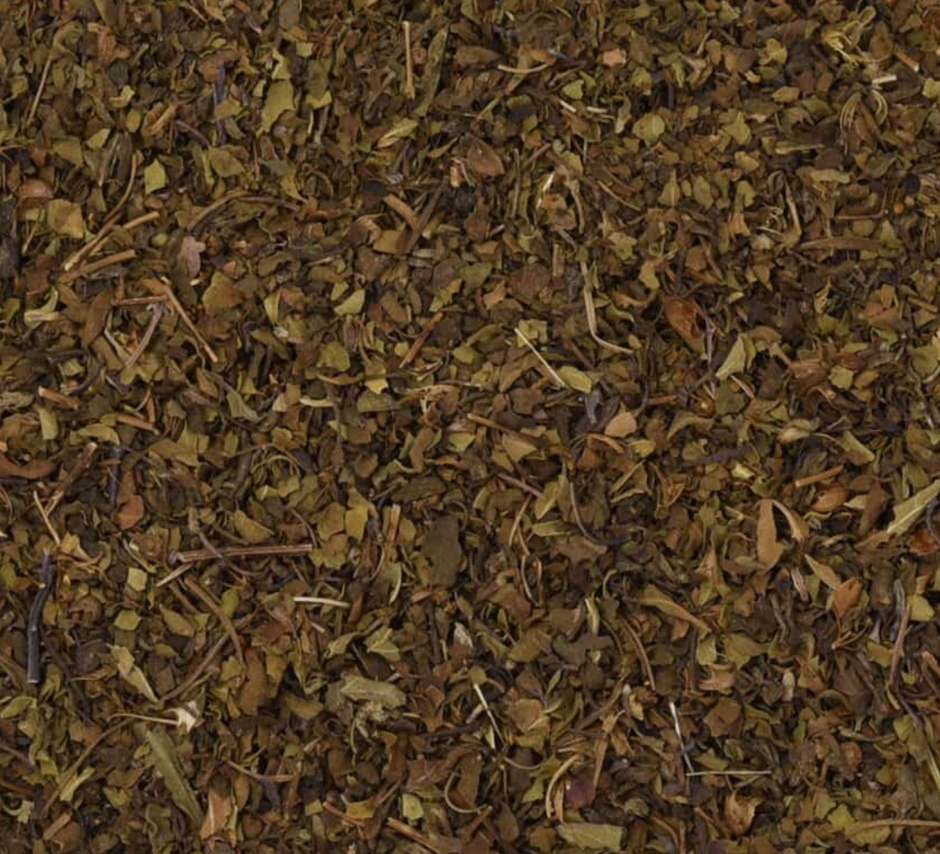 Close-up of dried holy basil/tulsi herb, showing chopped stems, leaves, and pieces used for teas and herbal remedies.