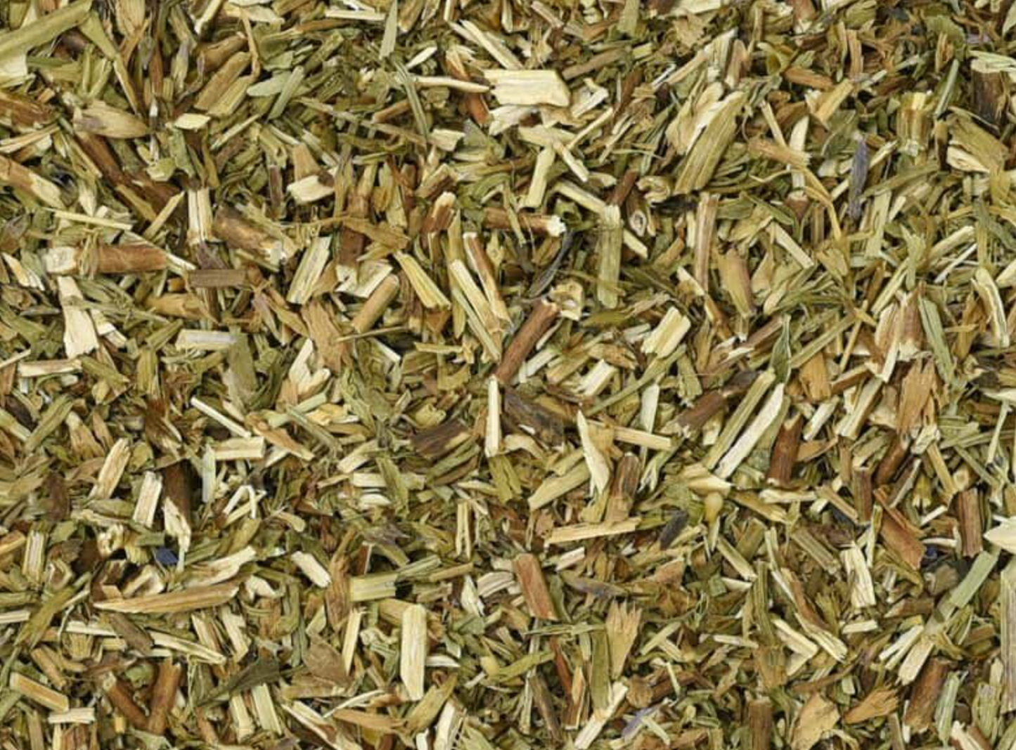 Close-up texture of dried hyssop herb, showing small green leaf pieces used for teas and herbal remedies.