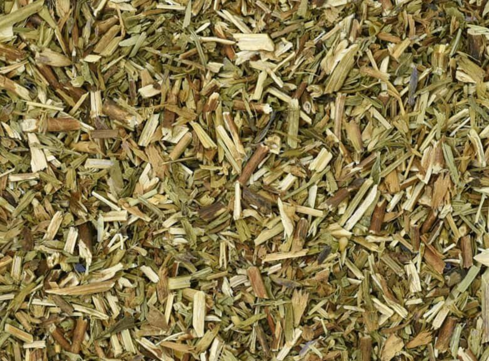 Close-up texture of dried hyssop herb, showing small green leaf pieces used for teas and herbal remedies.