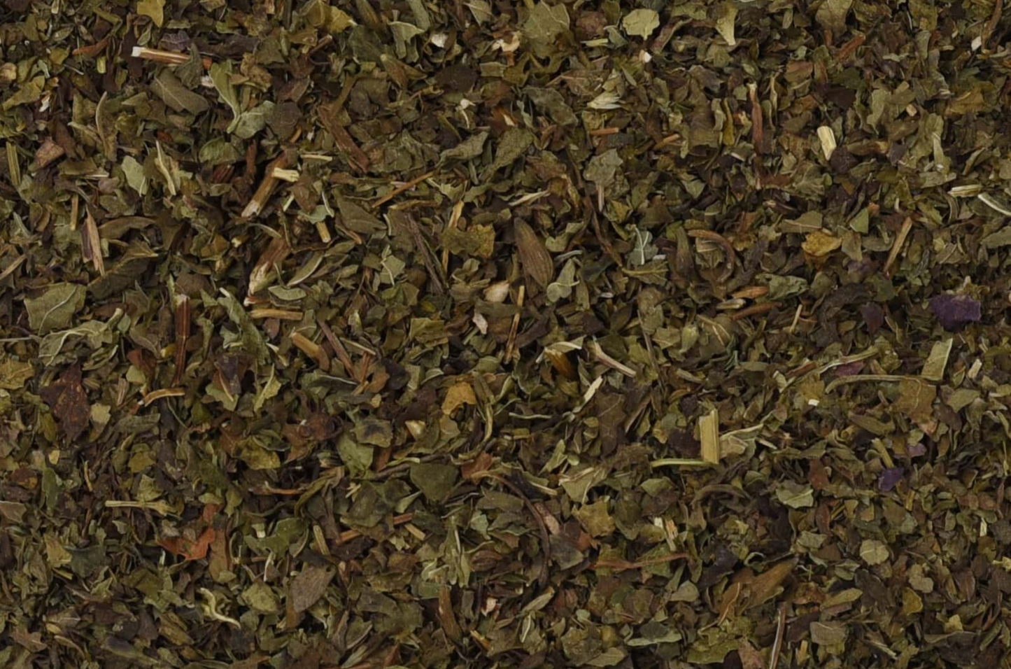 Close-up of dried lemon balm, showing chopped green leaves used for teas and herbal remedies.