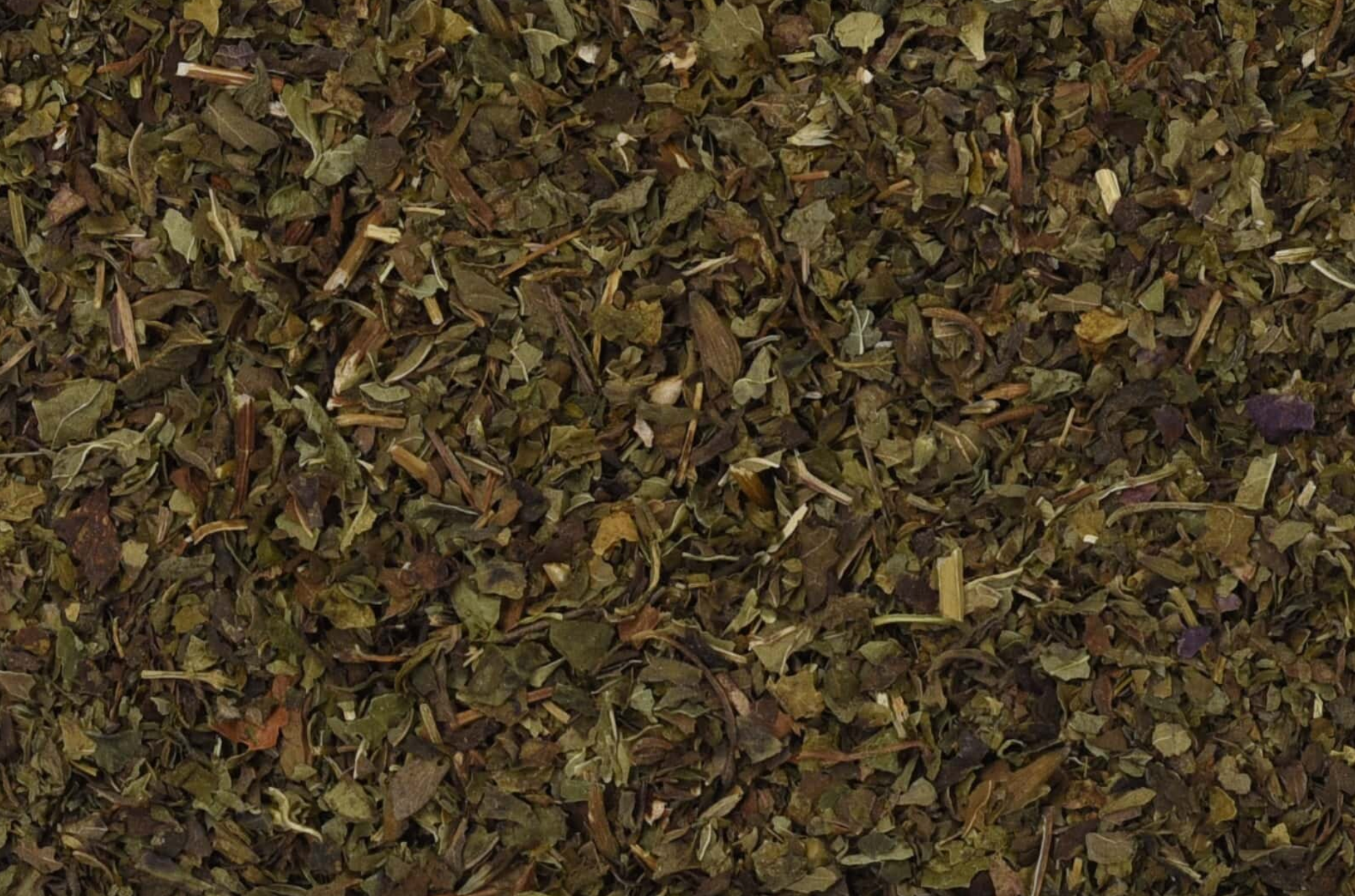 Close-up of dried lemon balm, showing chopped green leaves used for teas and herbal remedies.