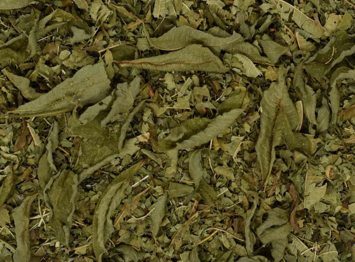 Close-up of dried lemon verbena, showing chopped green leaves used for teas and herbal remedies.