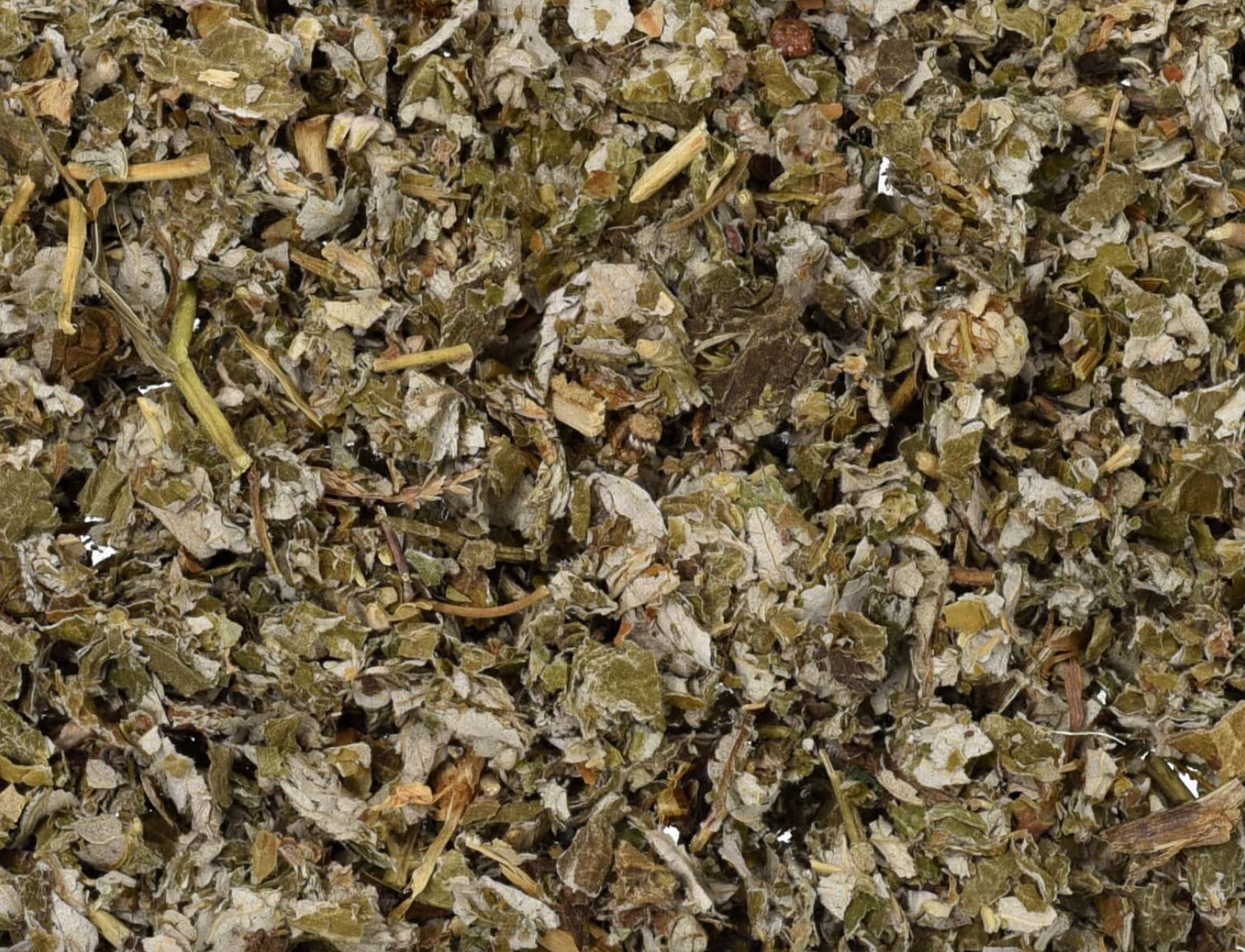 Close-up of dried raspberry leaf, showing chopped green leaves and pieces used for teas and herbal remedies.