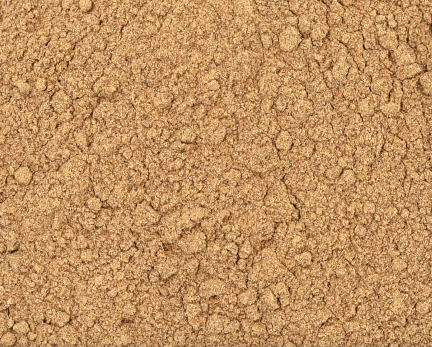 Close-up of dried reishi mushroom powder, showing fine beige powder used for teas and herbal remedies.