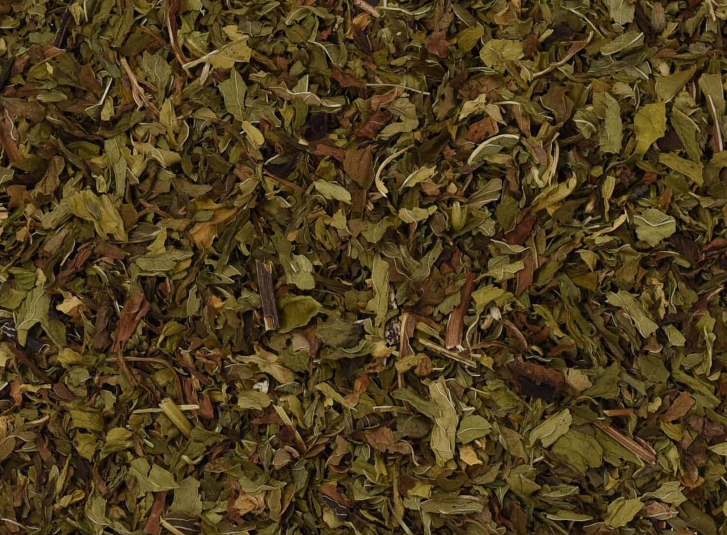 Close-up of dried spearmint herb, showing chopped green leaves used for teas and herbal remedies.