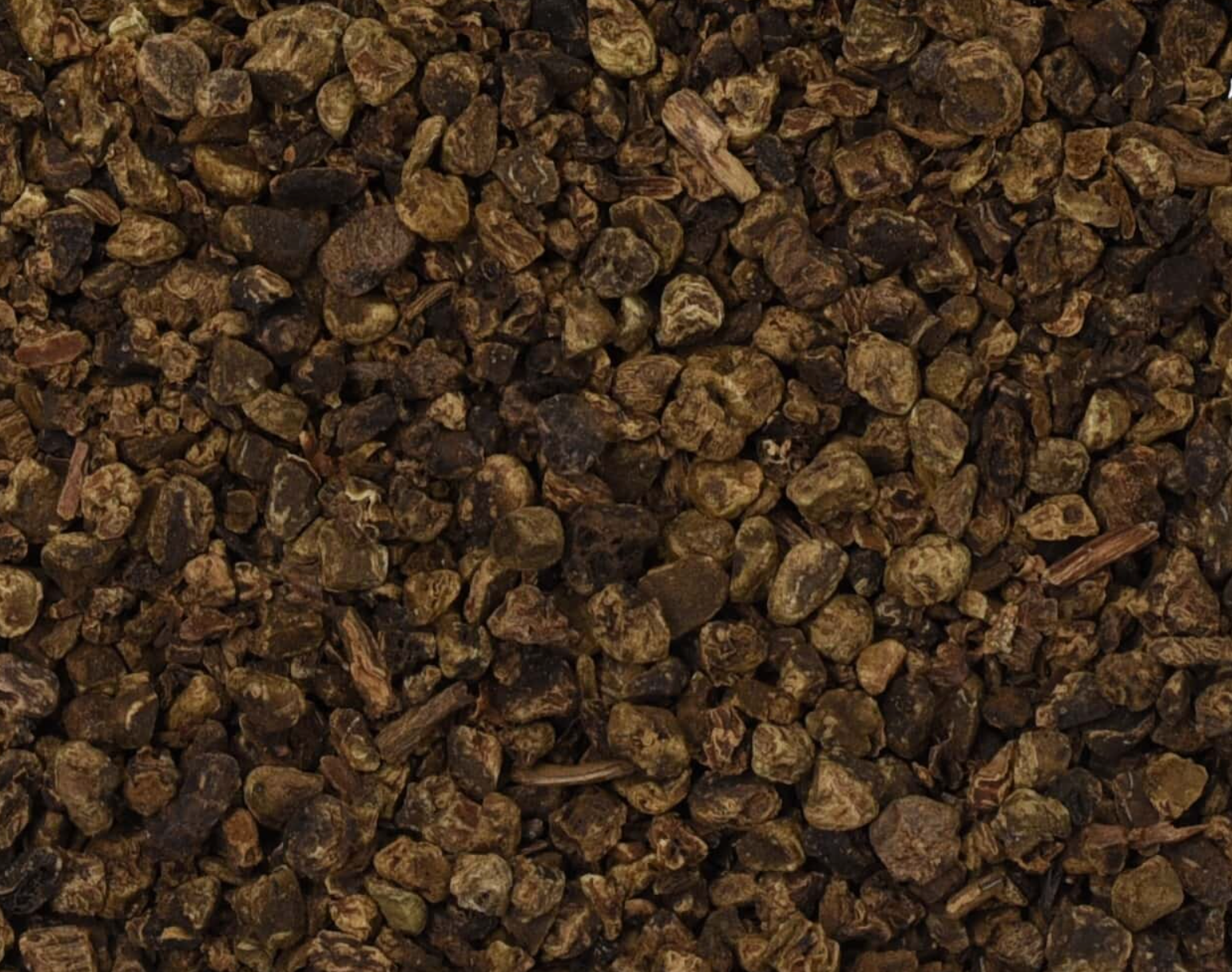 Close-up of dried valerian root, showing small dark brown chopped root pieces used for teas and herbal remedies.